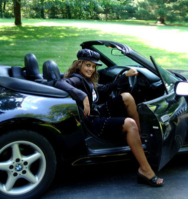 Sexy girl wearing a hat getting out of a convertible BMW